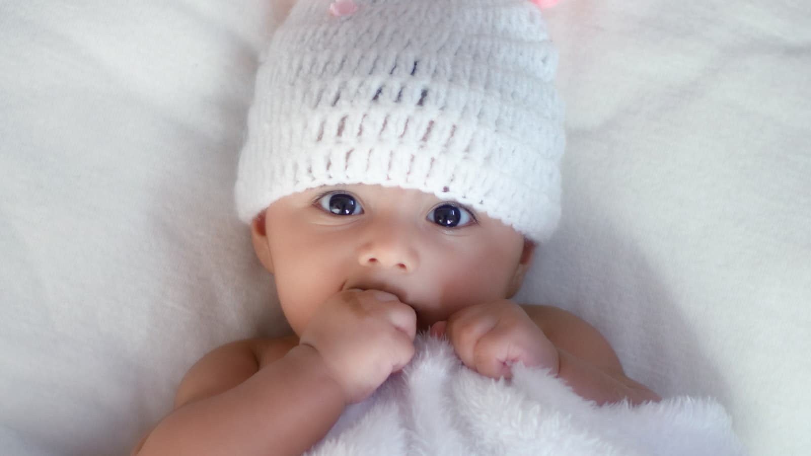 Newborn baby being gently posed in a studio basket setup