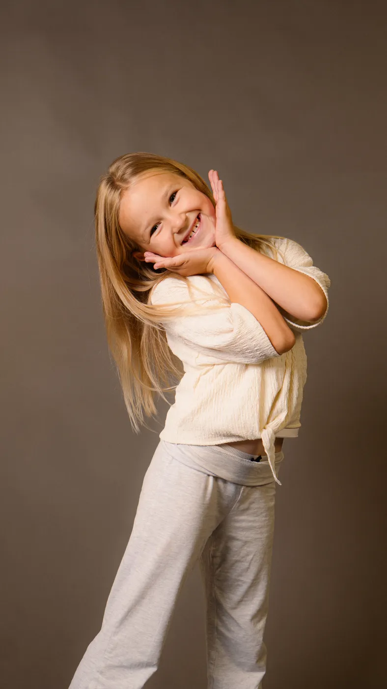 A young girl posing playfully in the studio