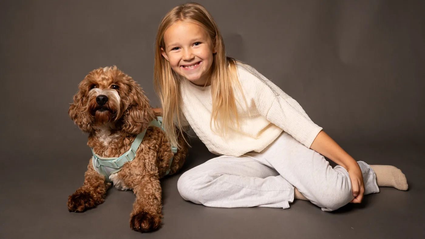 A young girl with her cockapoo in the studio