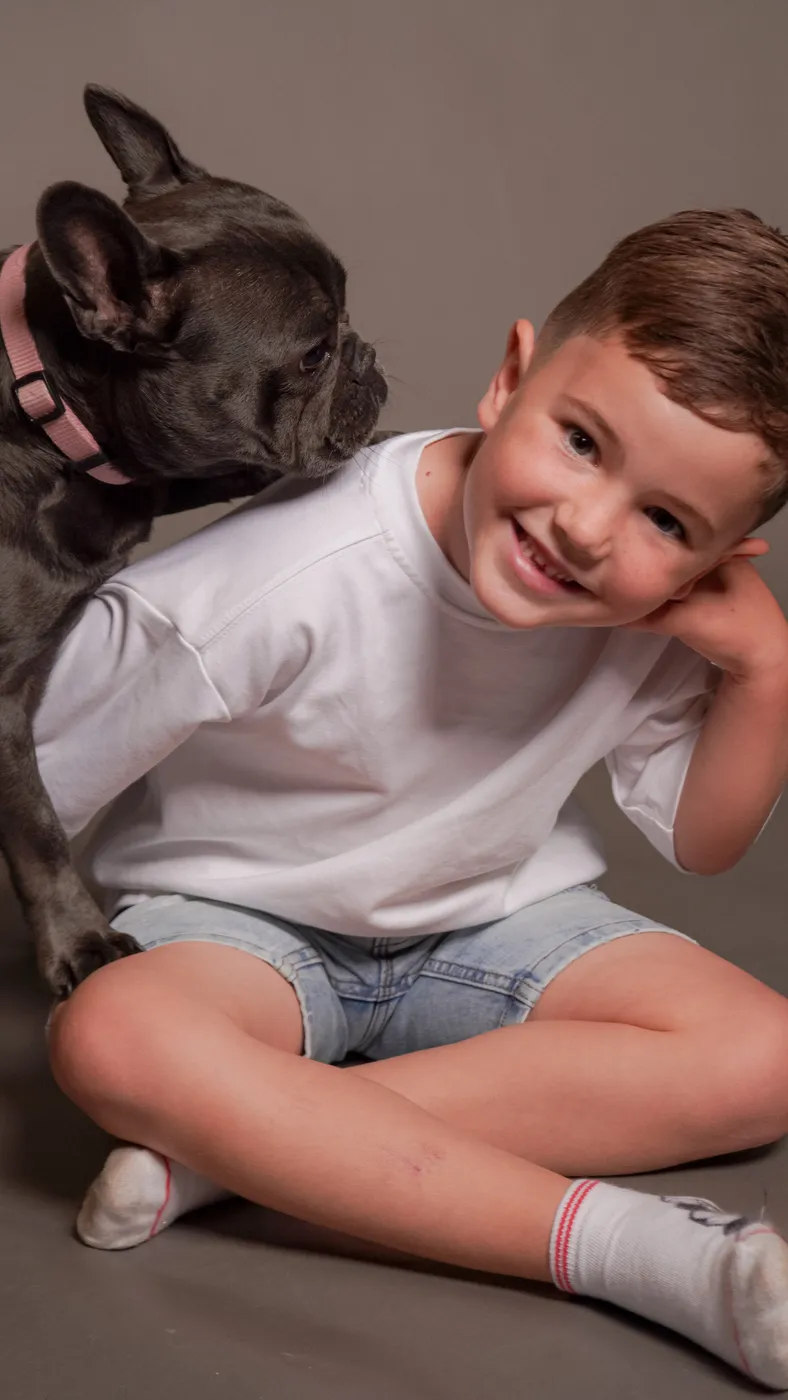 A young boy with a French bulldog