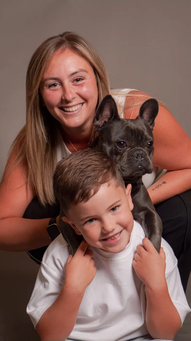 A woman and young boy with a French bulldog